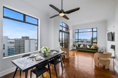 a living room with a table and a ceiling fan at Oh Darling! Auckland CBD Penthouse in Auckland