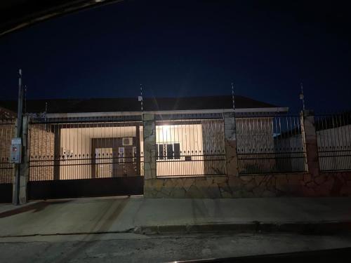 a large building with a fence and a gate at Casa Jardim Gramado in Cuiabá