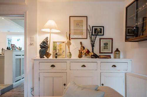 Un gran armario blanco en una sala de estar con una lámpara. en Historic 3 Bedroom Cottage in the Cotswolds, en Idbury