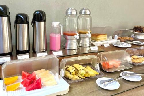 a table topped with trays of fruit and other food at Pousada Porto Rio in Parnaíba
