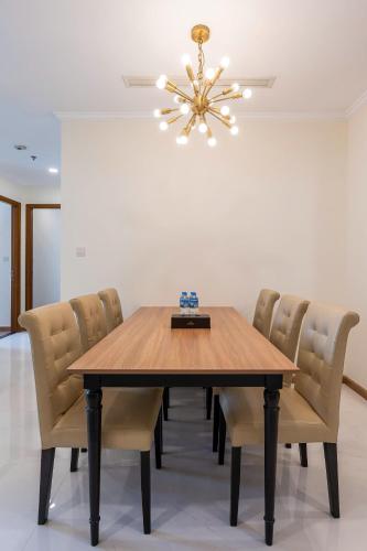 a dining room table with chairs and a chandelier at The Sun Avenue Apartment Moonlight in Ho Chi Minh City