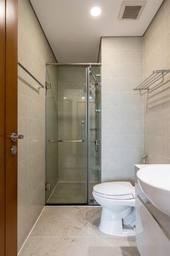 a bathroom with a shower and a toilet and a sink at The Sun Avenue Apartment Moonlight in Ho Chi Minh City