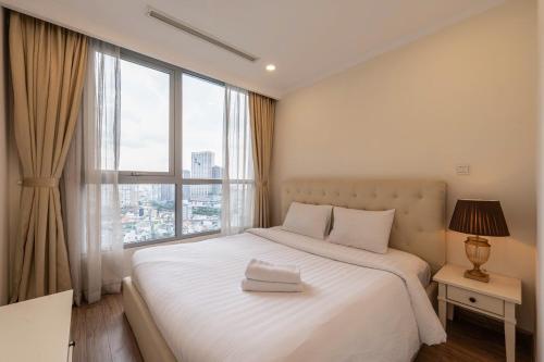 a bedroom with a large white bed with a window at The Sun Avenue Apartment Moonlight in Ho Chi Minh City