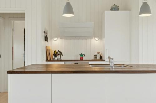 a kitchen with white cabinets and a sink at Family House With Sea View In Svinkløv in Andrup