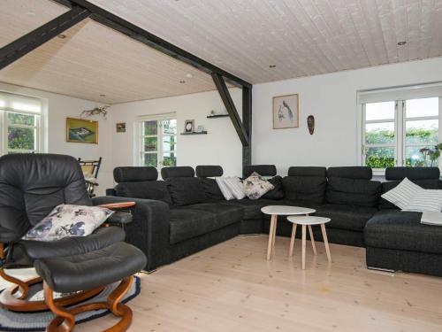 a living room with a black couch and chairs at 20 person holiday home in Ørsted in Ørsted