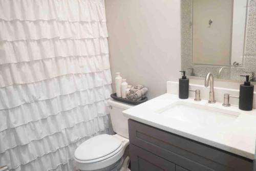 Un baño con inodoro, lavabo y espejo. en Calm & Cozy Modern Escape, en Atlanta