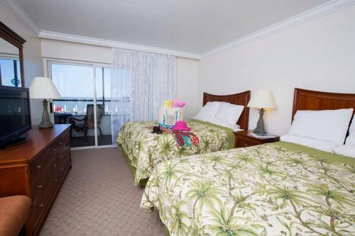 a hotel room with two beds and a television at Tween Waters Island Resort & Spa in Captiva