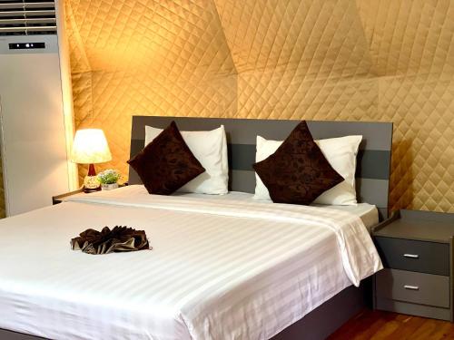 a bedroom with a large bed with a purse on it at Thisak Resort Cheung phnom kulen in Siem Reap