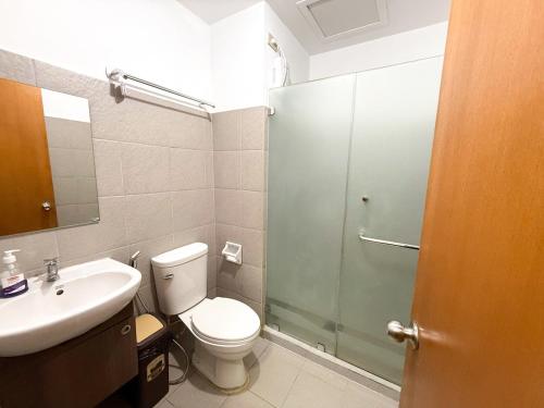 a bathroom with a toilet and a sink and a shower at Mellow Vibes City View in Davao City