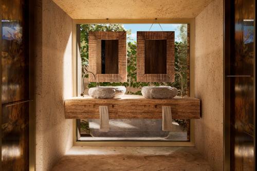 a bathroom with two sinks and a mirror at Nômade Temple Ibiza in Sineu