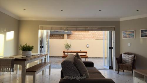 a living room with a couch and a table at Surf & Serenity on Sea, by Jono & Erik in Jeffreys Bay
