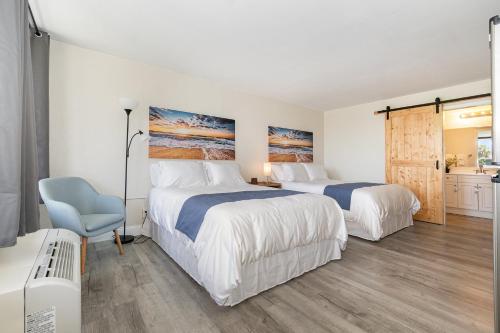 a bedroom with two beds and a blue chair at 2050 E IRLO BRONSON 1BED in Kissimmee