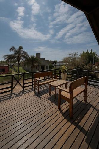 two benches on a wooden deck with a view of a park at Amplio departamento con 2 habitaciones- Balcón hacia la pileta y estacionamiento in Miramar