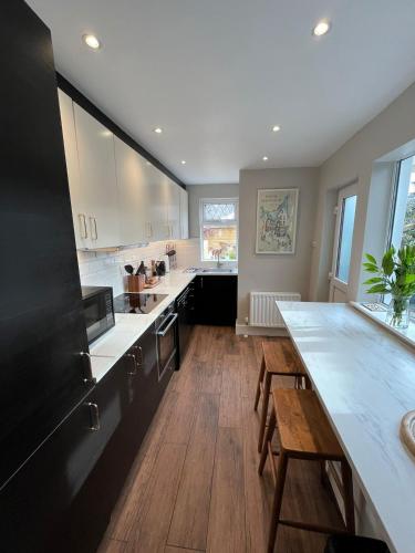a large kitchen with white counter tops and wooden floors at 3 Bedroom, 5 Bed Home in the Heart of Galway in Galway