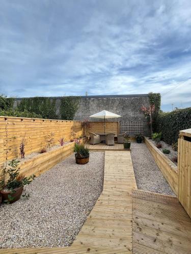 a garden with a wooden fence and a patio at 3 Bedroom, 5 Bed Home in the Heart of Galway in Galway