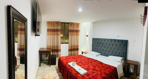 une chambre avec un grand lit avec une couverture rouge dans l'établissement Hotel World Peru, à Lima