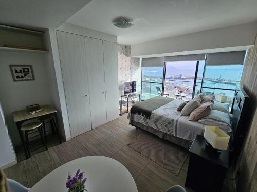 a bedroom with a bed and a view of the ocean at Experencia Puerto Nuevo-1hab-1Bano in Antofagasta