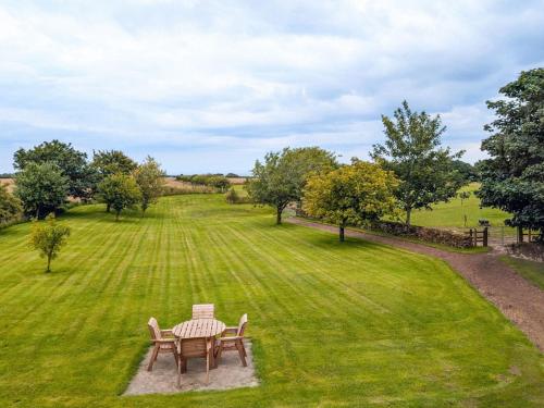 a table and chairs in a field of grass at May Cottage in Hackness