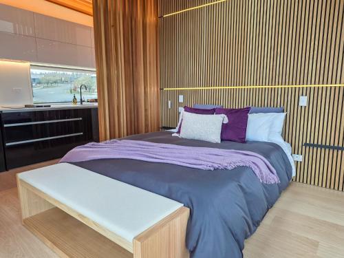 a bedroom with a large bed with purple blankets and pillows at Lakeview Tekapo in Lake Tekapo