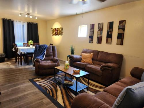 a living room with leather couches and a table at 2-bed condo, cook-ready kitchen, and laundry, 5-8 minutes from University of Arizona and downtown Tucson in Tucson