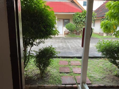 a window view of a yard with a brick path at Go Gear Travel & Bungalow in Krabi town