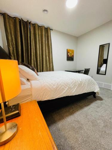 a bedroom with a bed and a desk with a lamp at Modern 2-bed 1-bath Suite in Calgary
