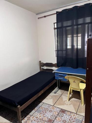 a room with a bed and a desk and a table at República Boemia in Ouro Preto