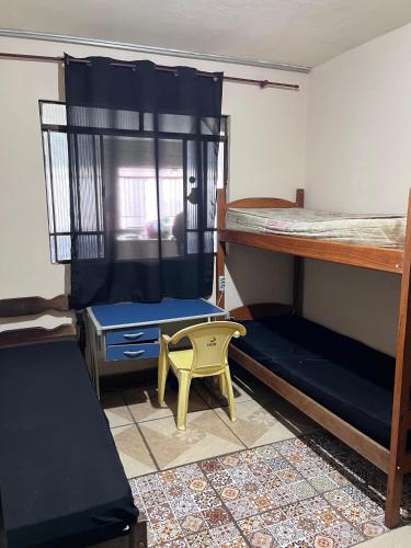a room with two bunk beds and a yellow stool at República Boemia in Ouro Preto