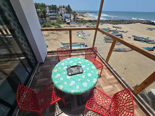 a table and chairs on a balcony with a beach at Divine Beach Resorts in Puducherry