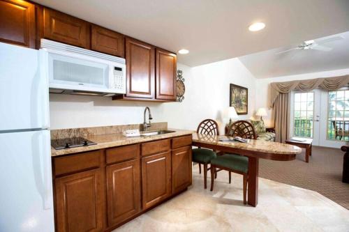 a kitchen with wooden cabinets and a table in a room at Tween Waters Island Resort & Spa in Captiva