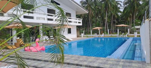 a swimming pool in front of a house at Chilly Beach Resort Palawan in Aborlan