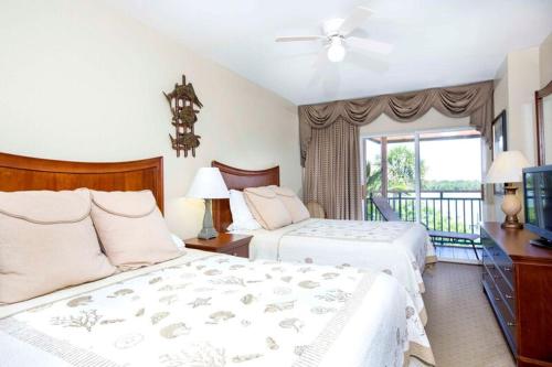 a bedroom with two beds and a balcony at Tween Waters Island Resort & Spa in Captiva