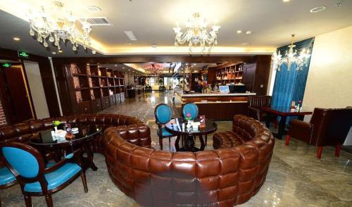 a restaurant with a leather bar with tables and chairs at James Joyce Coffetel Golmud Huaxing Plaza Branch in Golmud