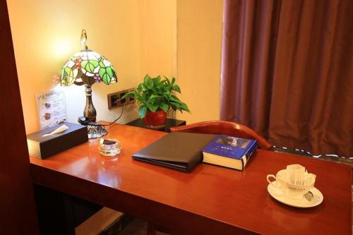 a desk with a laptop computer and books on it at James Joyce Coffetel Golmud Huaxing Plaza Branch in Golmud