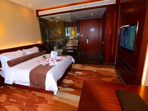 a hotel room with a bed and a television at James Joyce Coffetel Golmud Huaxing Plaza Branch in Golmud
