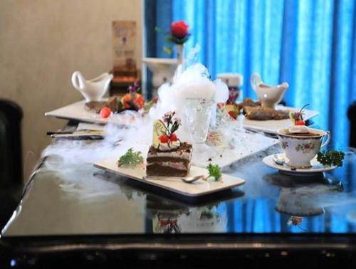 a table with several plates of food and cups of coffee at James Joyce Coffetel Golmud Huaxing Plaza Branch in Golmud