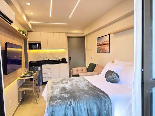 a hotel room with a bed and a kitchen at Flat em Porto de Galinhas com Varanda, Aconchegante, Próximo ao Mar e ao Centro Comercial in Porto De Galinhas