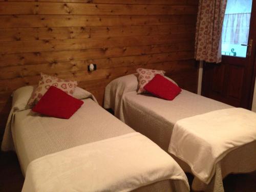 Challand Saint VictorにあるMaison des Challantの赤い枕付きのベッド2台が備わる客室です。