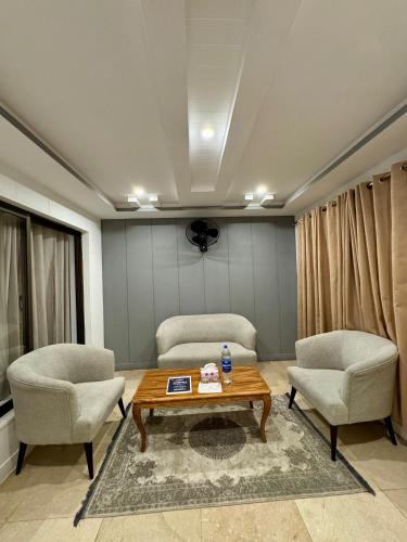 a living room with two chairs and a coffee table at Al Noor Starlet Hotel in Skardu