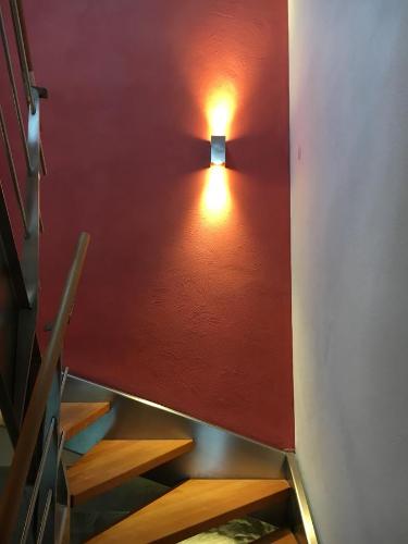 ein Treppenhaus mit einem Licht an einer roten Wand in der Unterkunft Casa Manderscheid in Manderscheid