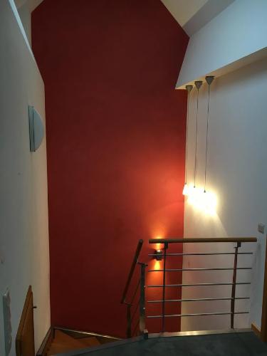 eine Treppe mit einer roten Wand und einem Licht darauf in der Unterkunft Casa Manderscheid in Manderscheid