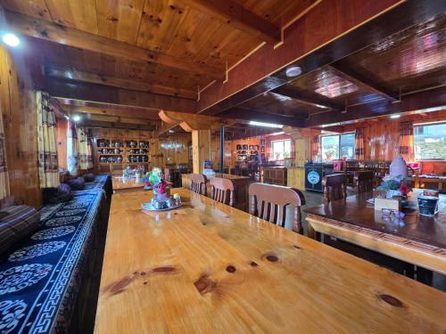 a dining room with a large wooden table and chairs at Mountain View Lodge in Lukla