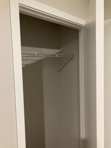 a closet with a glass door with a metal shelf at 408B Jervois Street Mayfair in Hastings