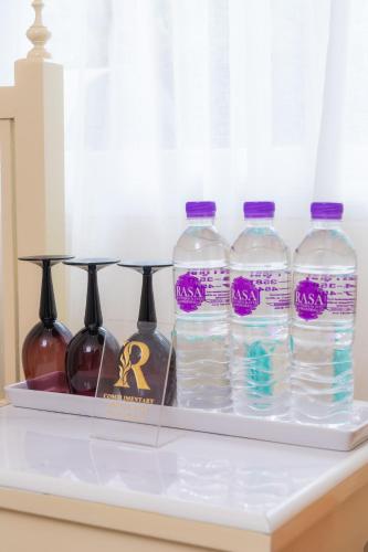 a shelf with four bottles of water on a counter at Rasa Boutique Hotel Chiang Rai in Chiang Rai