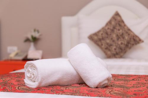 a roll of white towels sitting on a bed at Rasa Boutique Hotel Chiang Rai in Chiang Rai