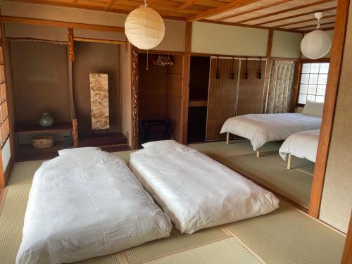 a room with two large white beds in it at MYOJI HOUSE 2 Traditional Japanese Stay in Katsuragi
