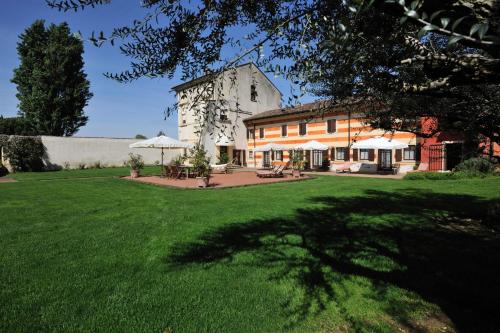 a large house with a large yard with green grass at Musella Winery & Relais in San Martino Buon Albergo