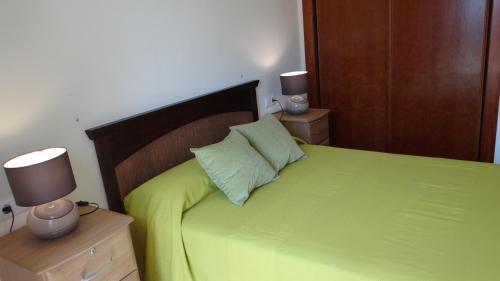 a bedroom with a green bed with two night stands at Vera Rental Thalassa I in Vera