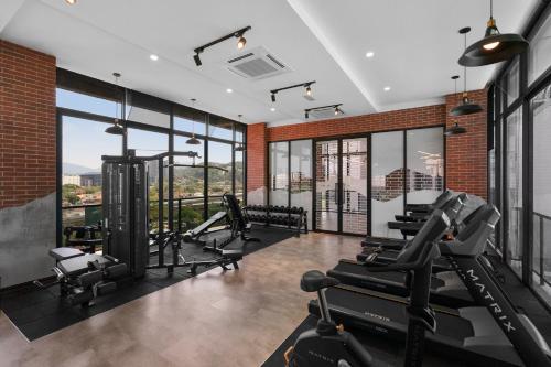 a gym with treadmills and cardio equipment and windows at Astoria Ampang By Grabstay in Kuala Lumpur