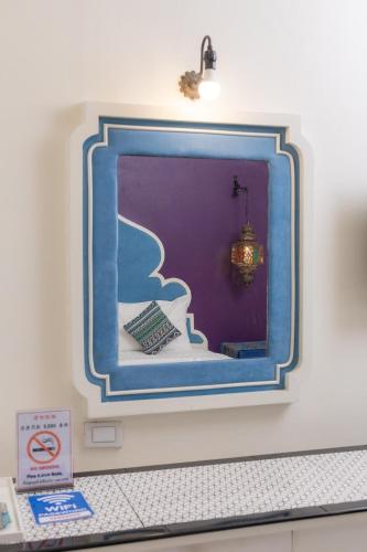a mirror on a wall in a room at Rasa Boutique Hotel Chiang Rai in Chiang Rai
